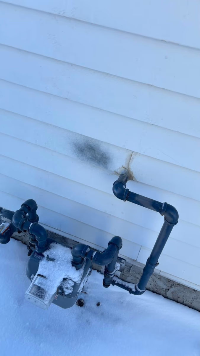 Siding damage at a gas meter — before repair